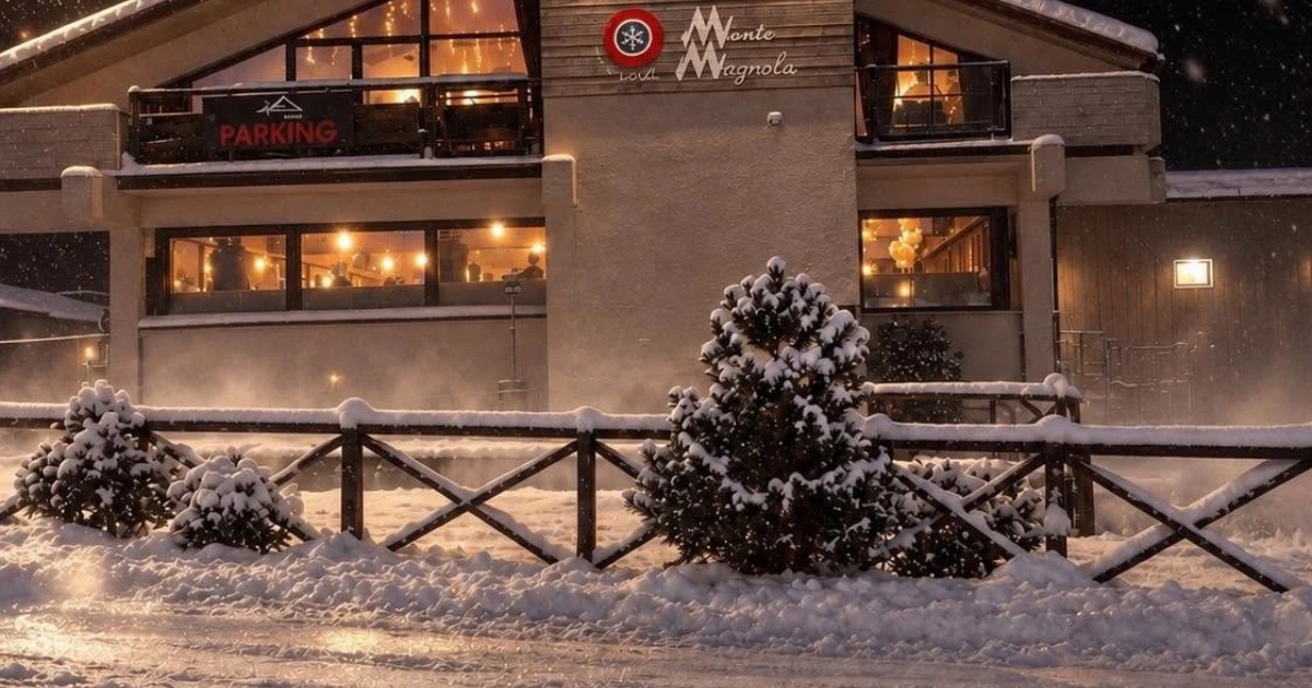 Il Cibivacco di notte sotto la neve, con le finestre illuminate e l'insegna sulla facciata
